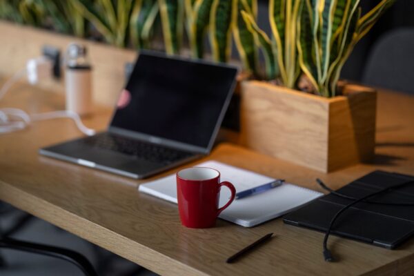 Setup de mesa minimalista com laptop e caderno para uso de ferramentas essenciais