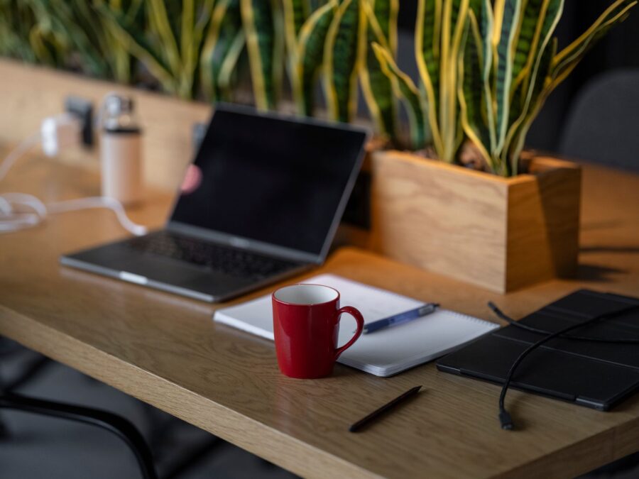 Setup de mesa minimalista com laptop e caderno para uso de ferramentas essenciais